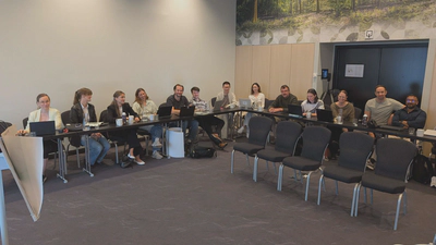 Doctoral researchers and principal investigators in the plenary room.